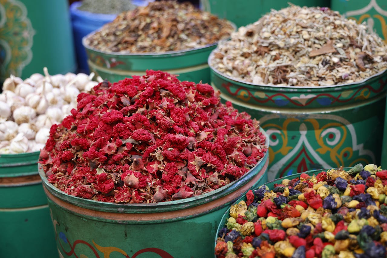 Vivid display of dried flowers and herbs in vibrant market bins, showcasing a rich variety of spices.
